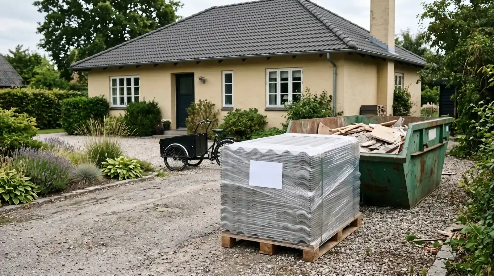 Eternitplader pakket ind i plast ved siden af affaldscontainer