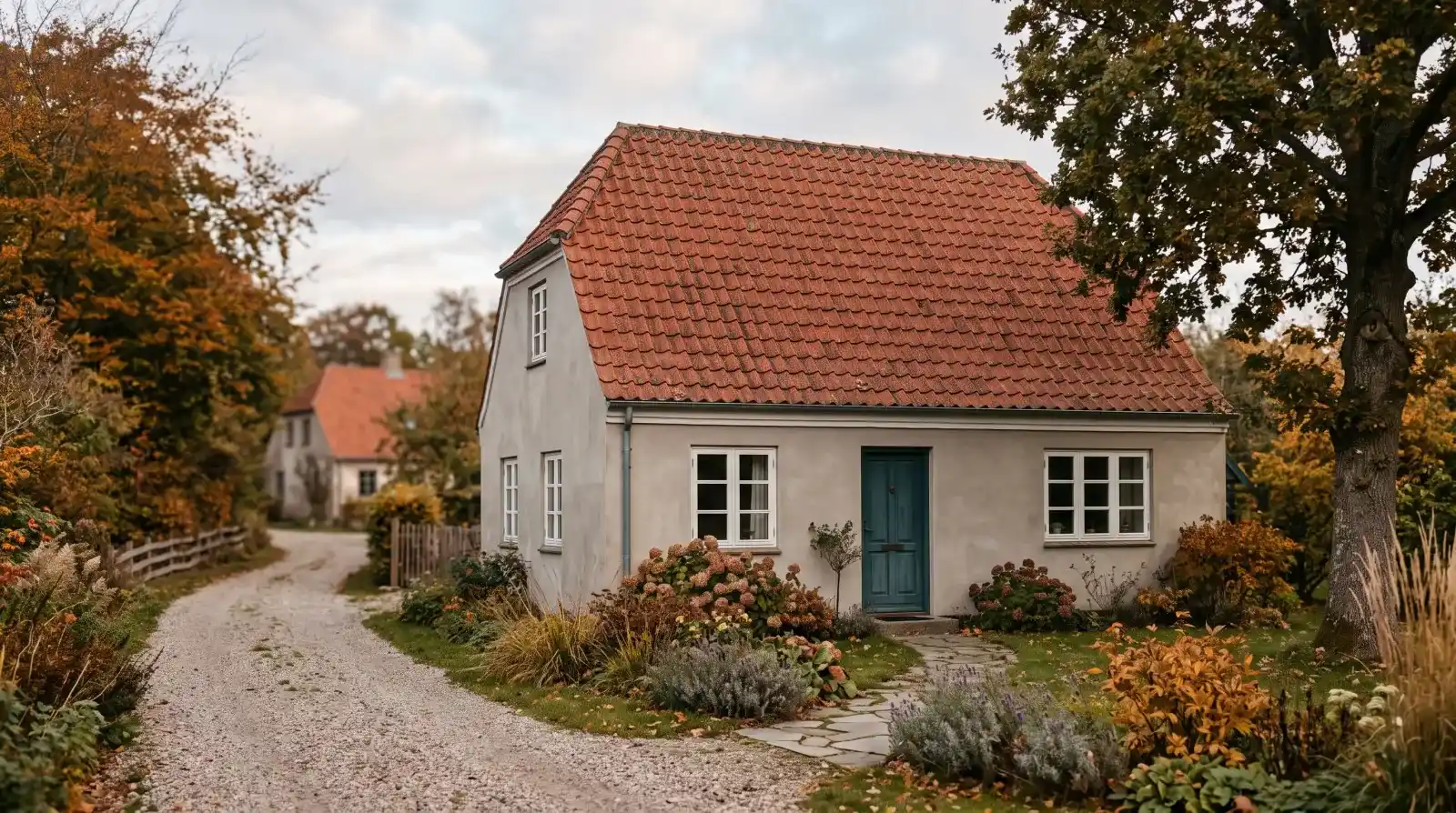 Rødt tegltag på hus i blødt efterårslys